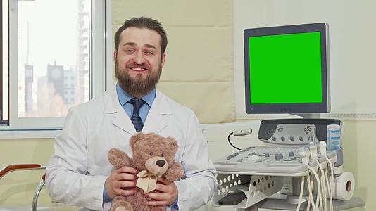 泰迪熊儿科医生的背面有一个绿色屏幕的超声波扫描仪视频的预览图