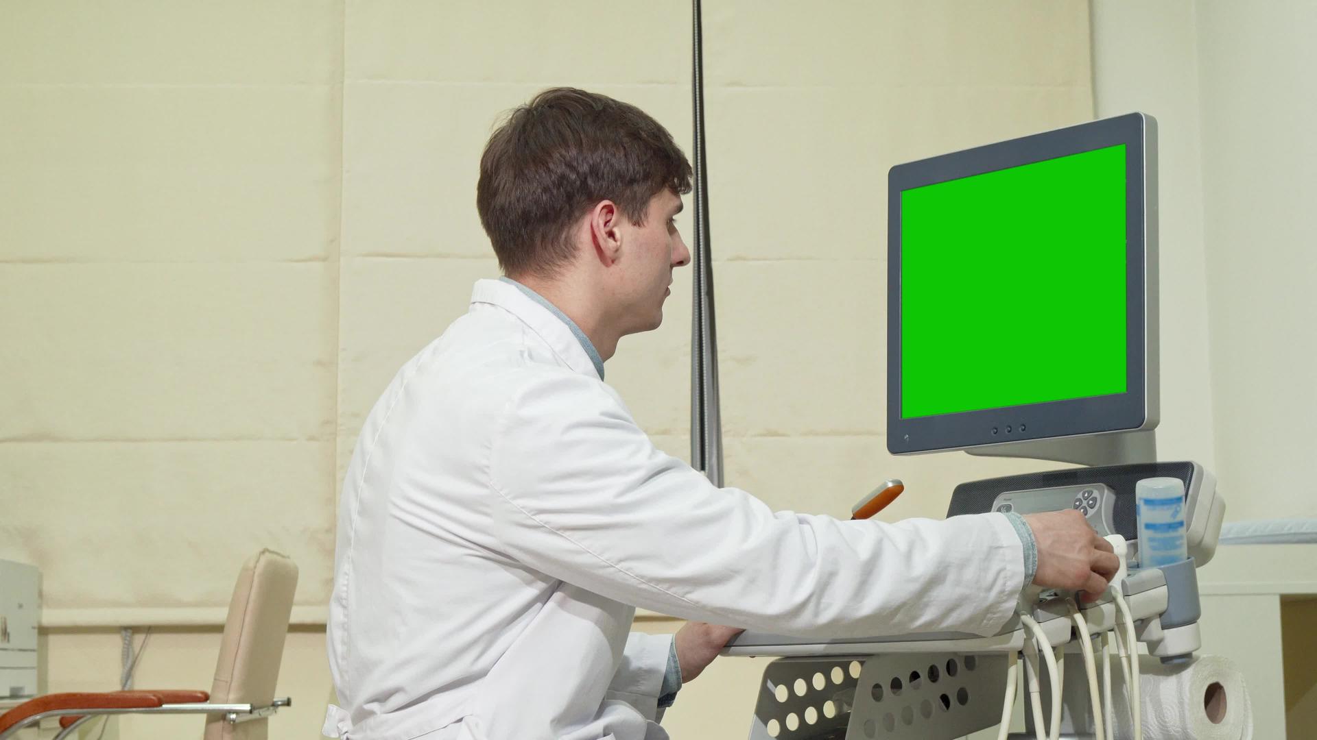 年轻男医生使用绿屏超声波扫描仪视频的预览图