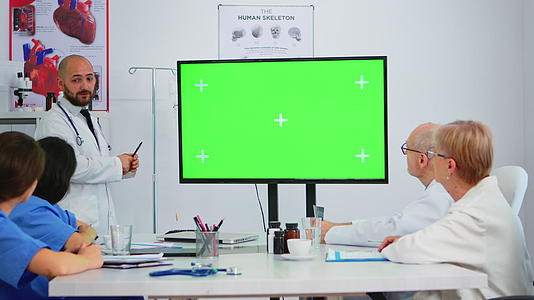 医生通过预览绿屏监视器来解释会议问题视频的预览图
