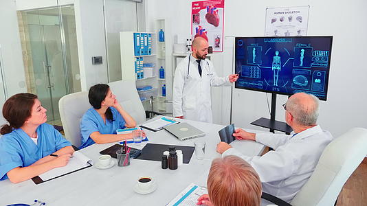 在谈到保健时医学专家用数字监视器指向医疗设备视频的预览图