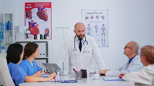专业医生站在提交医疗报告的同事面前视频的预览图