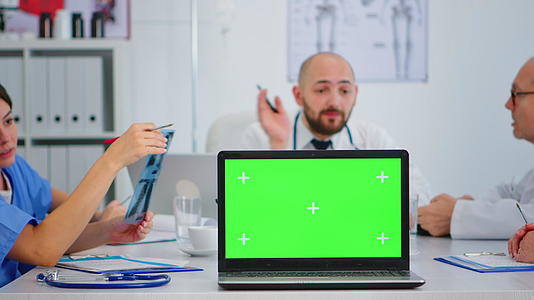 一组医生在镜头前用绿色屏幕放置笔记本电脑视频的预览图