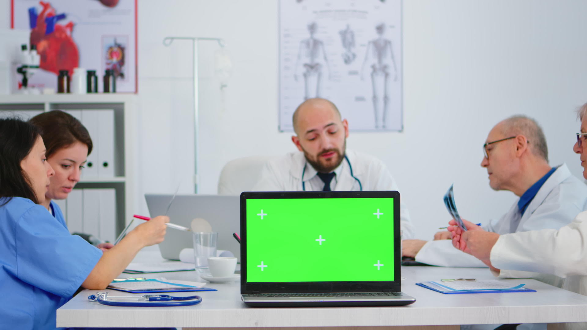 一组医生在镜头前使用带有绿色屏幕的笔记本电脑视频的预览图