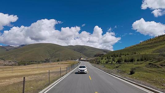 4k蓝天白云下的藏区公路沿途自然风光行车视角视频的预览图