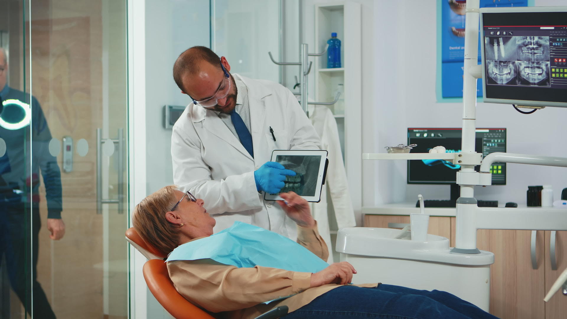 口腔科学家与高级患者一起检查牙齿X光视频的预览图