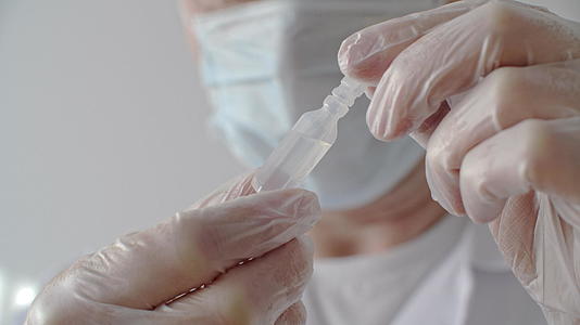 用医用手套合上医生的手戴上带有抗疫苗的安瓿视频的预览图