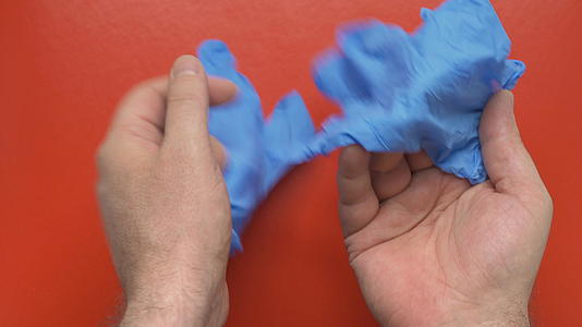 蓝色消毒手套的红色背景视频的预览图