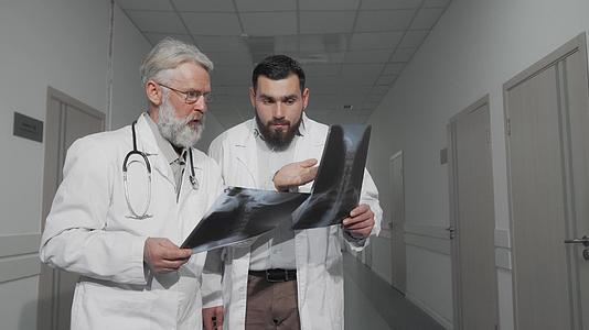两名医生在医院走廊进行X光扫描时一起交谈视频的预览图