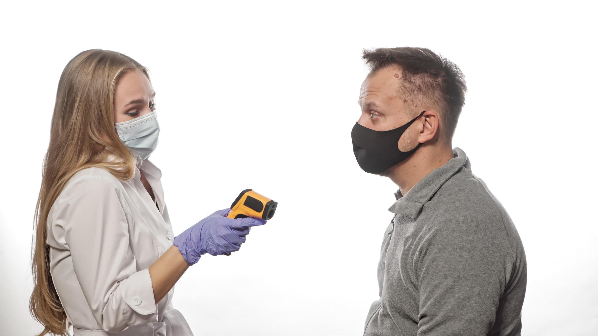 非接触式温度计护士使用医用口罩测量患者或员工视频的预览图