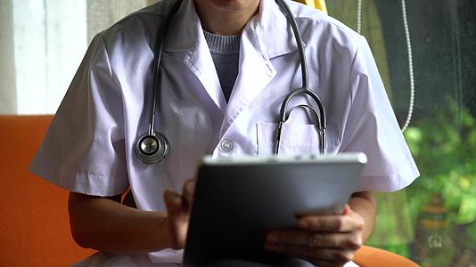 手动医生使用数字平板电脑进行远程医疗在线治疗视频的预览图