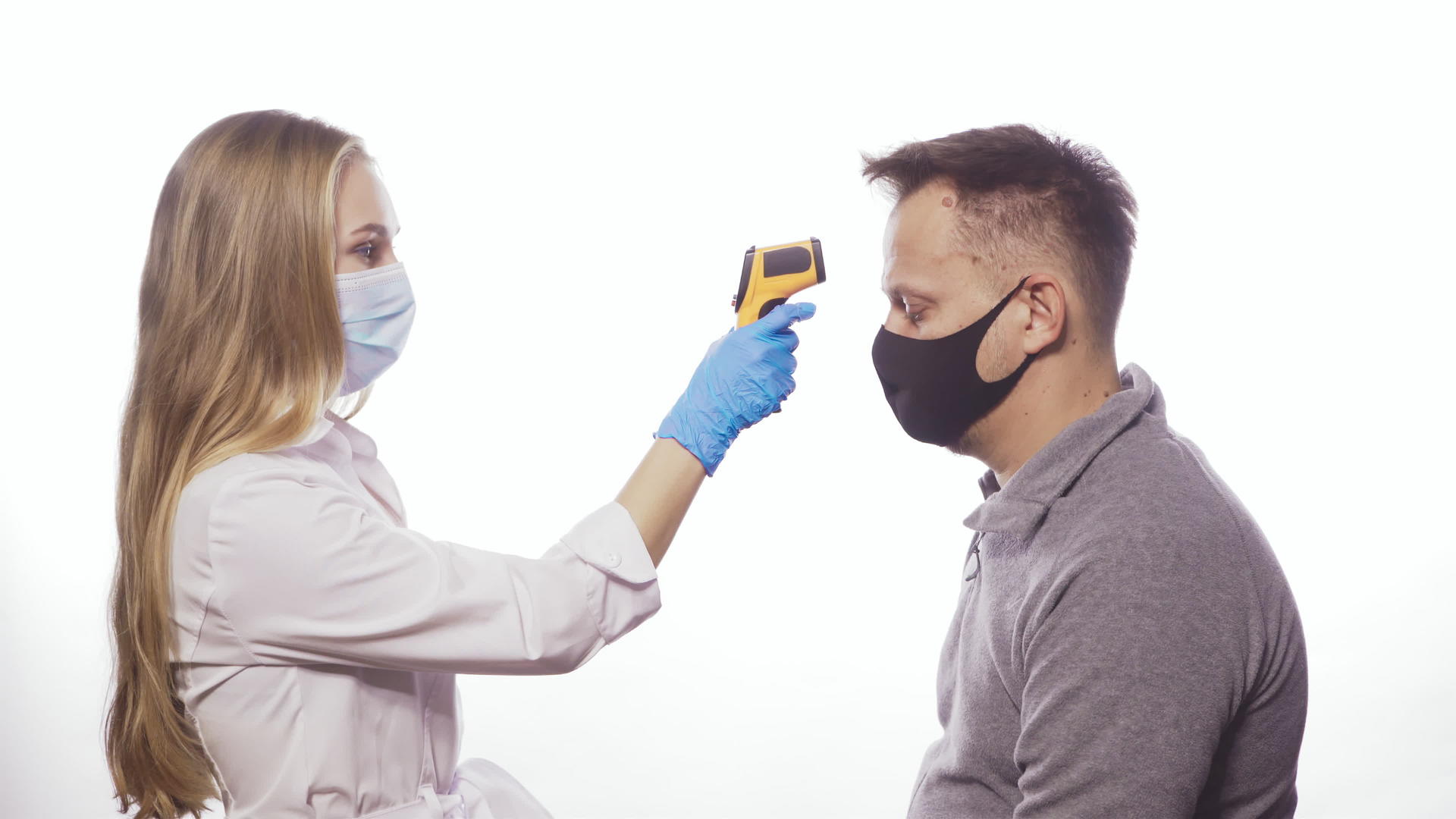 戴医用口罩的护士使用非接触式温度计测量患者或员工视频的预览图