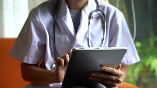 医生使用数字平板电脑进行远程医疗在线治疗视频的预览图