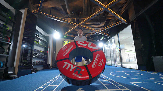 4k健身房运动男性力量训练抱轮胎负重练习视频的预览图