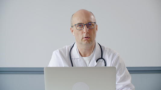 专业的耳听器医生在网上看着相机说话视频的预览图