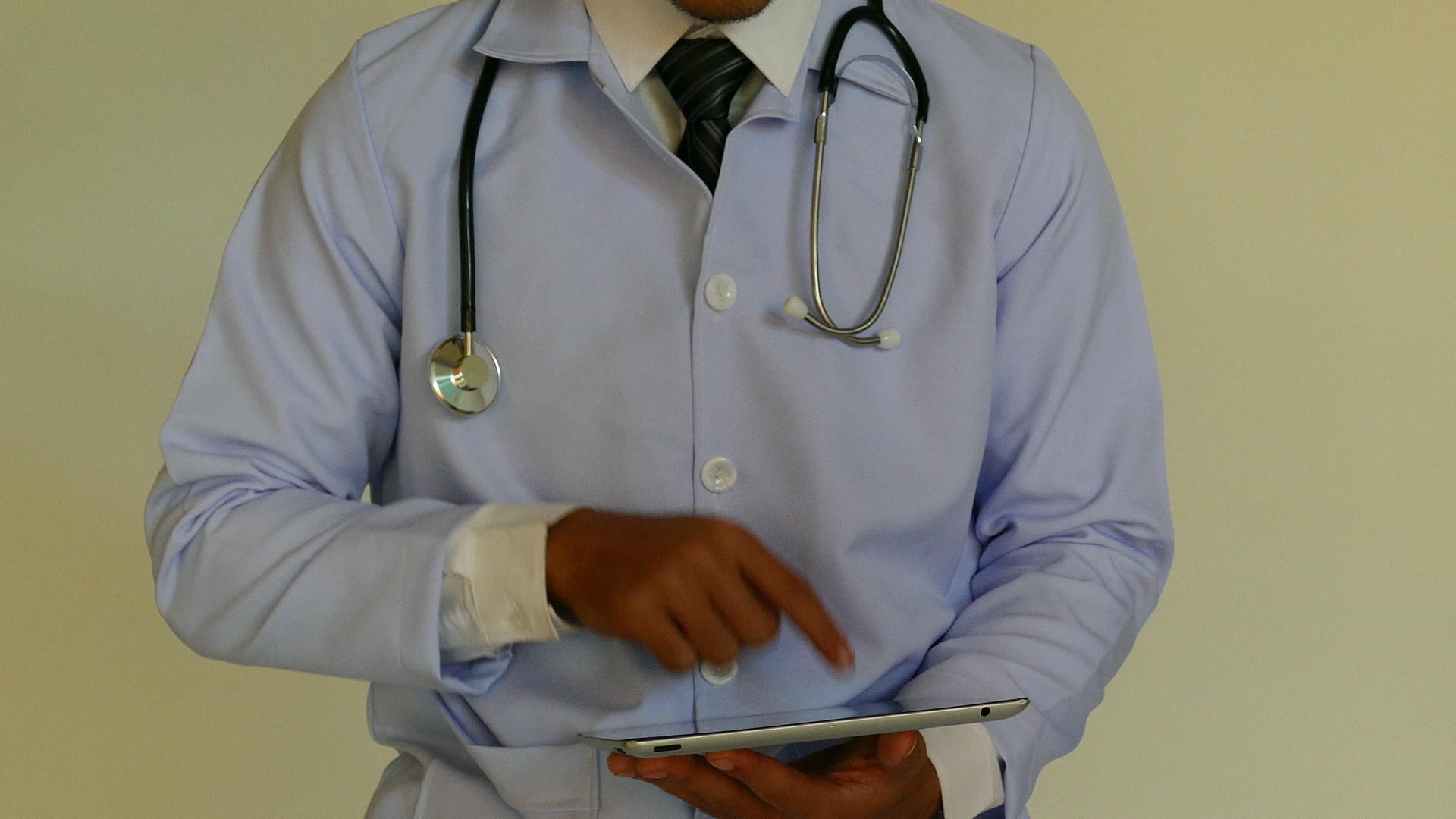 年轻医生用数字平板电脑触摸屏幕脖子上戴着听诊器视频的预览图