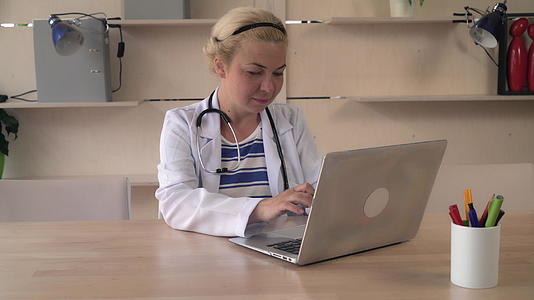 女医生坐在木桌上视频的预览图