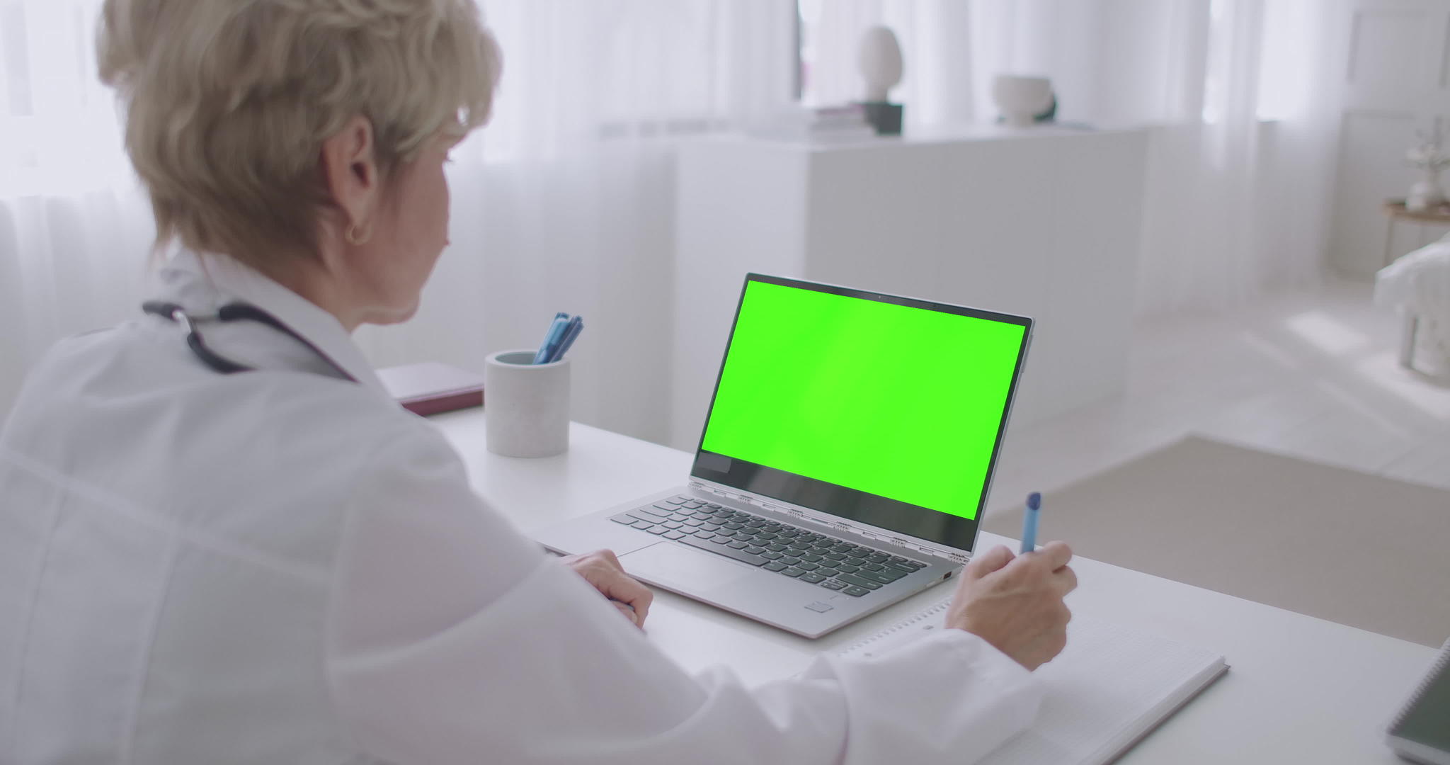 女医生正在观看用于铬关键技术的笔记本电脑的在线研讨会视频的预览图