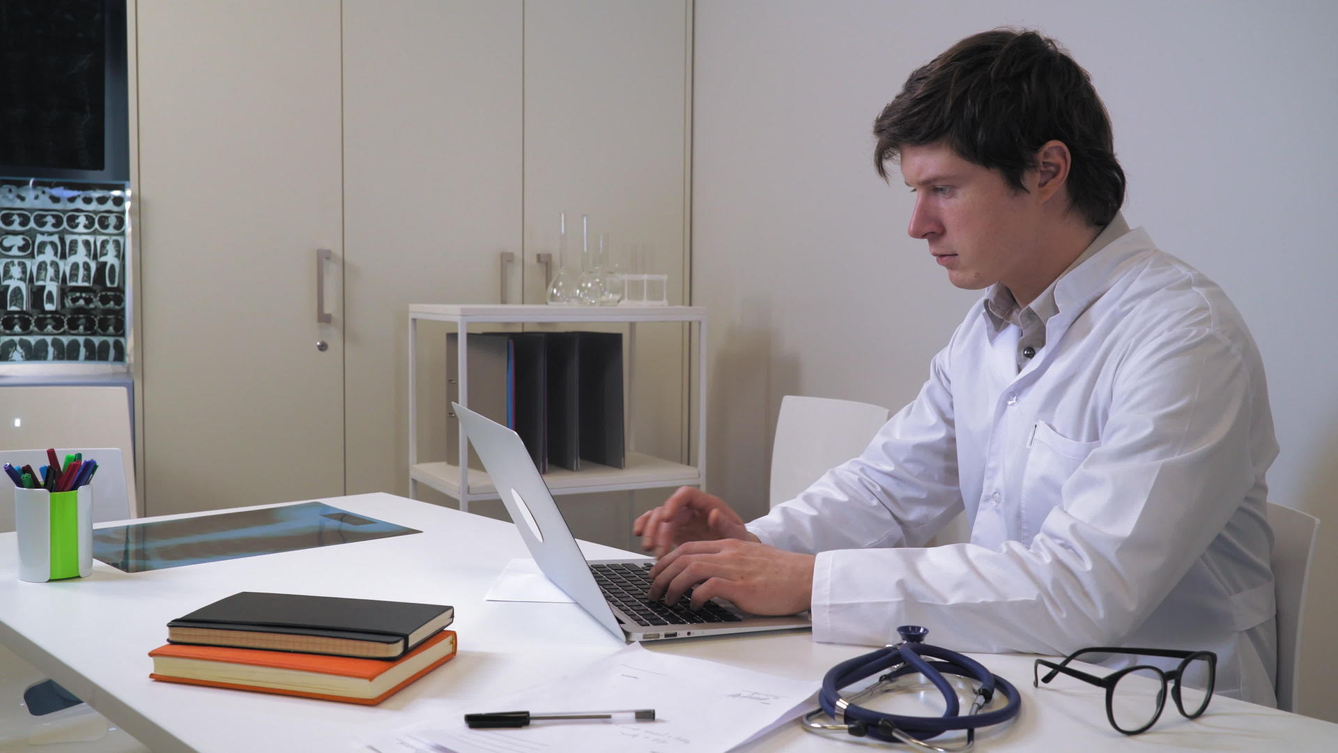 英俊的caucasian治疗师在办公室用笔记本电脑视频的预览图