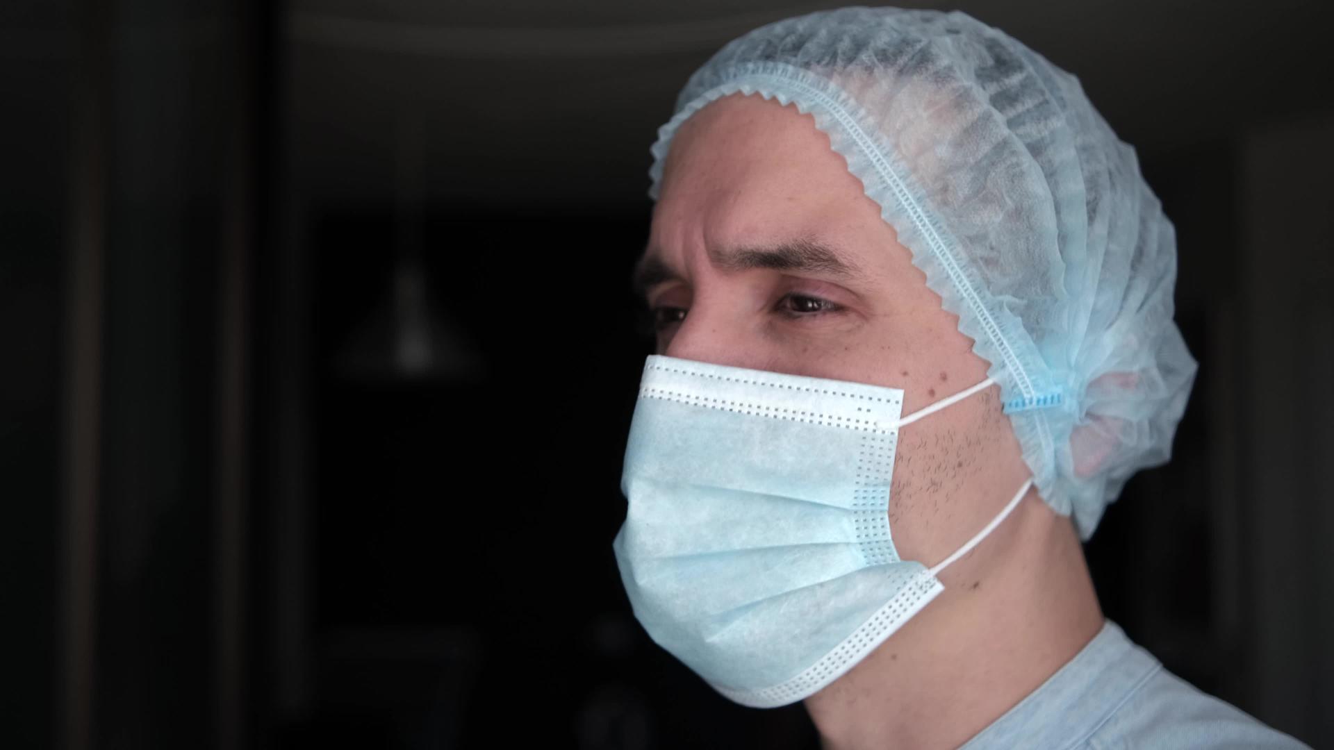一位疲惫的医生戴着防护面具的男医生视频的预览图