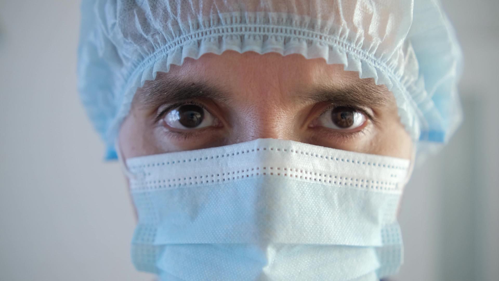 一位疲惫的男医生戴着防护面具视频的预览图