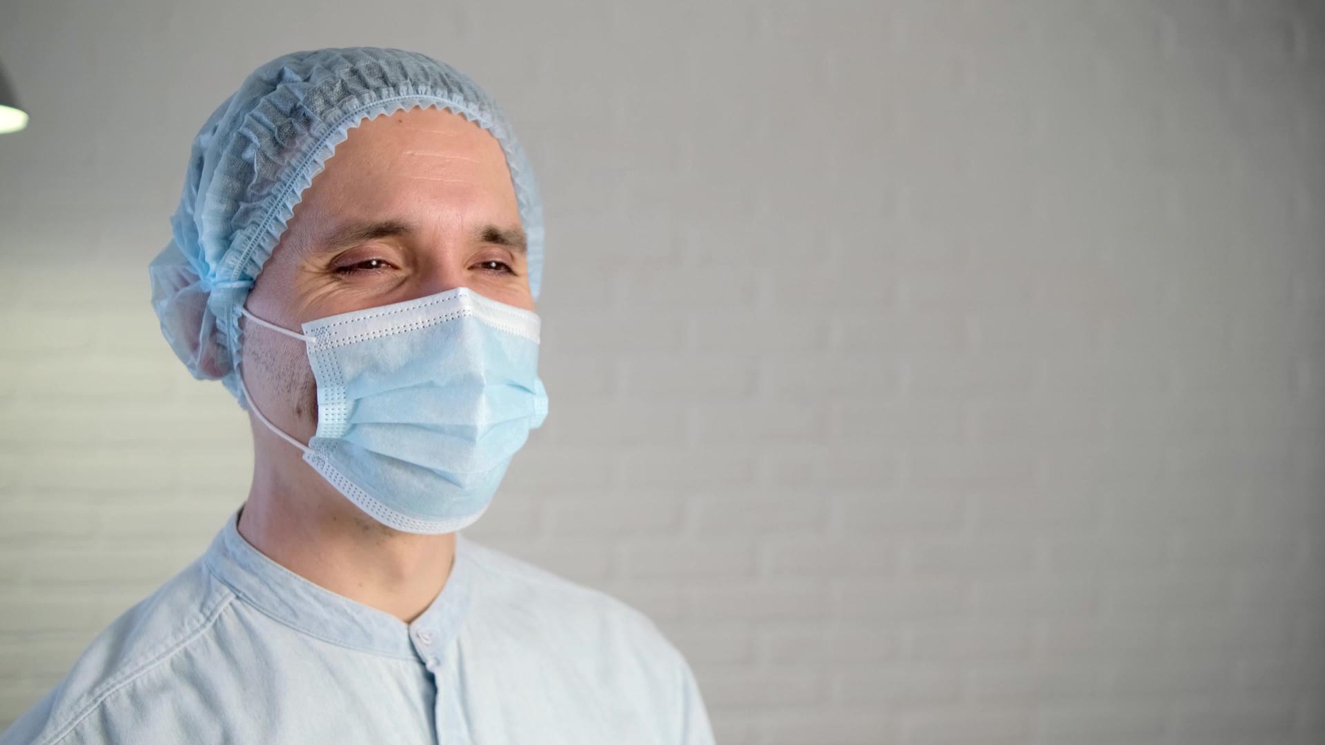 一名疲惫的男性医生在疾病期间戴着保护性口罩使用疲劳的医生视频的预览图