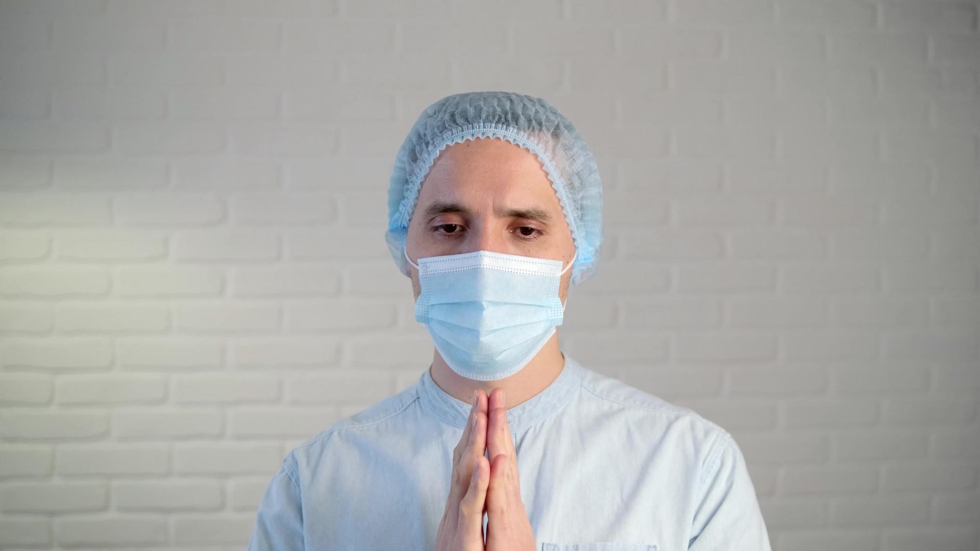 一名男性医生在生病期间戴着保护性口罩一名疲劳医生视频的预览图