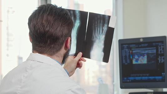 一名男性医生正在看病人的脚x光片视频的预览图