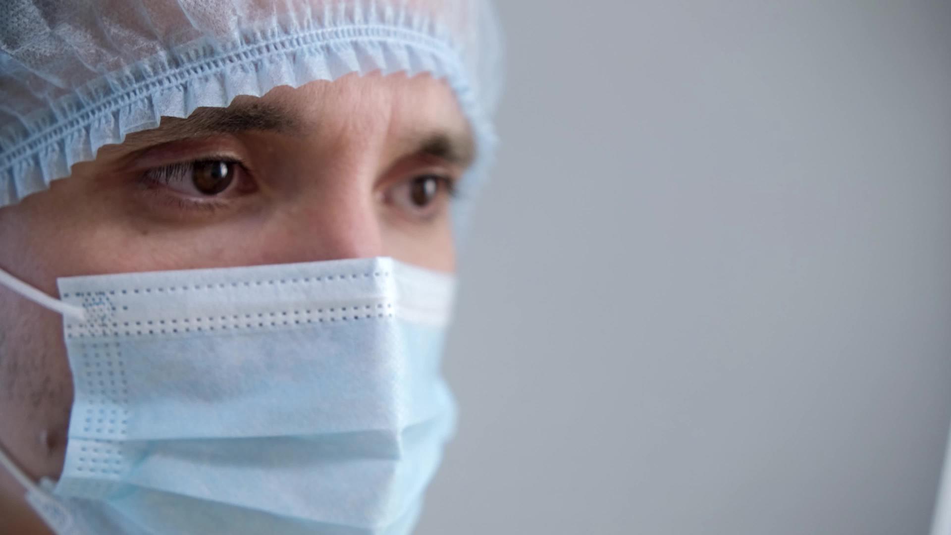 在此期间一名戴着防护面具的男医生将目光移开避开视频的预览图