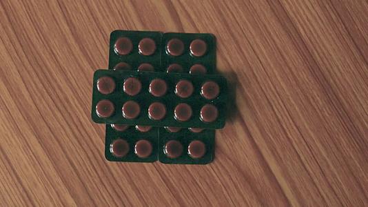 抗生素药丸中的胶囊堆积在泡水器的圆形药片或木桌底部视频的预览图