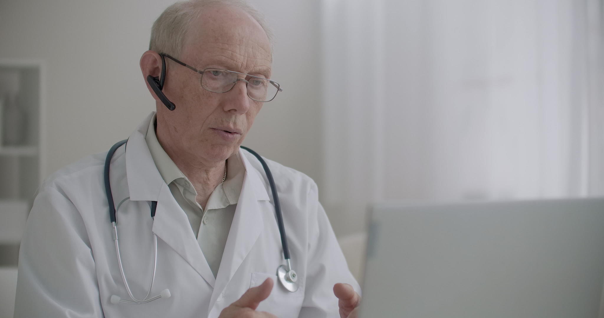 老年医学专家通过笔记本电脑上的网络摄像头在诊所办公室视频的预览图