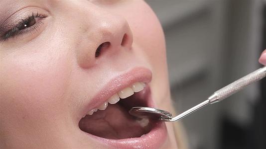 牙医把牙镜放在病人的嘴上视频的预览图