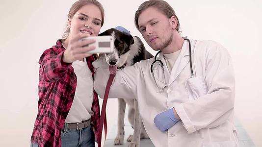 检查结束后和可爱的狗在兽医那里拍照视频的预览图
