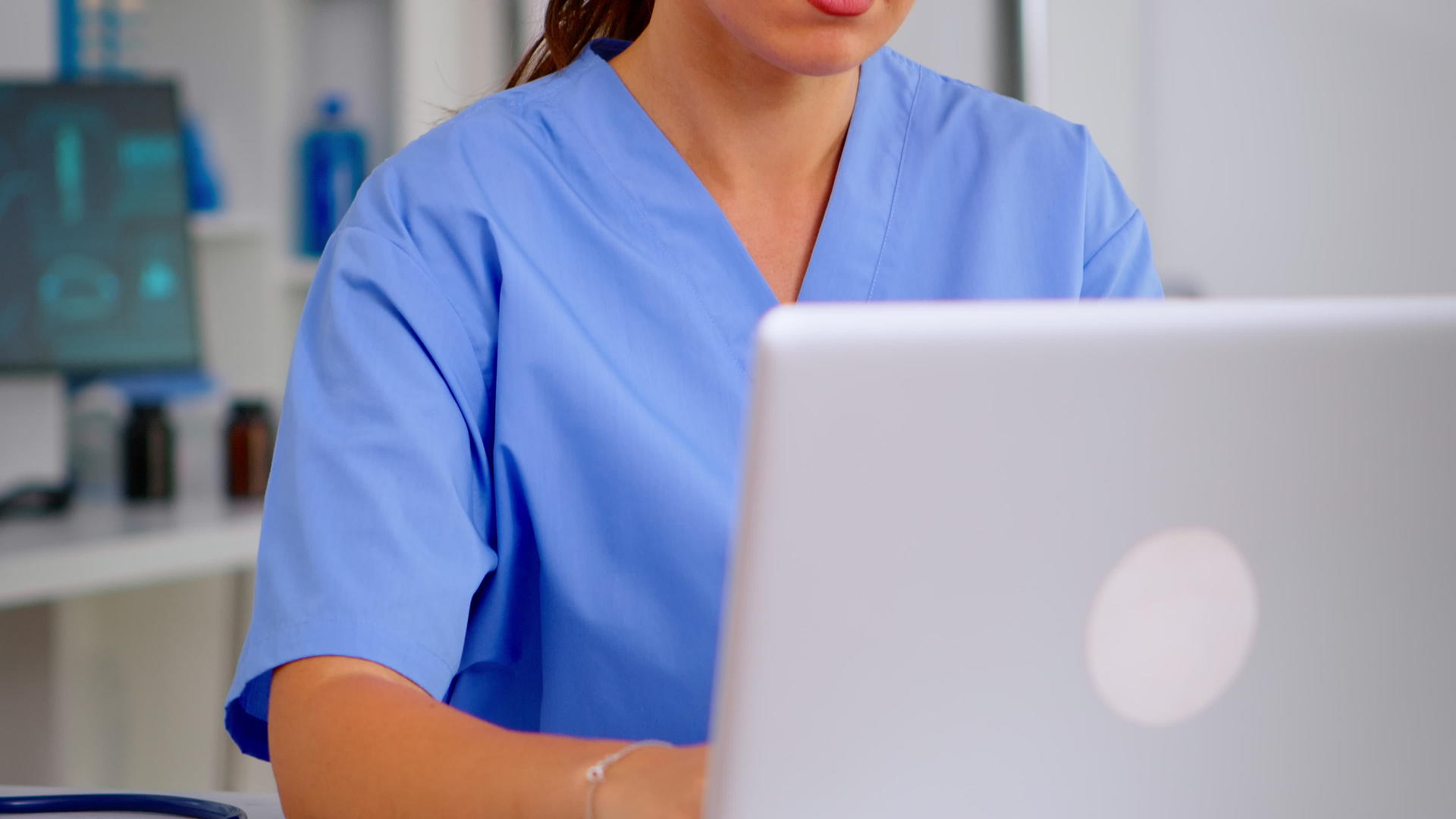 医生穿着蓝色外套使用电脑视频的预览图