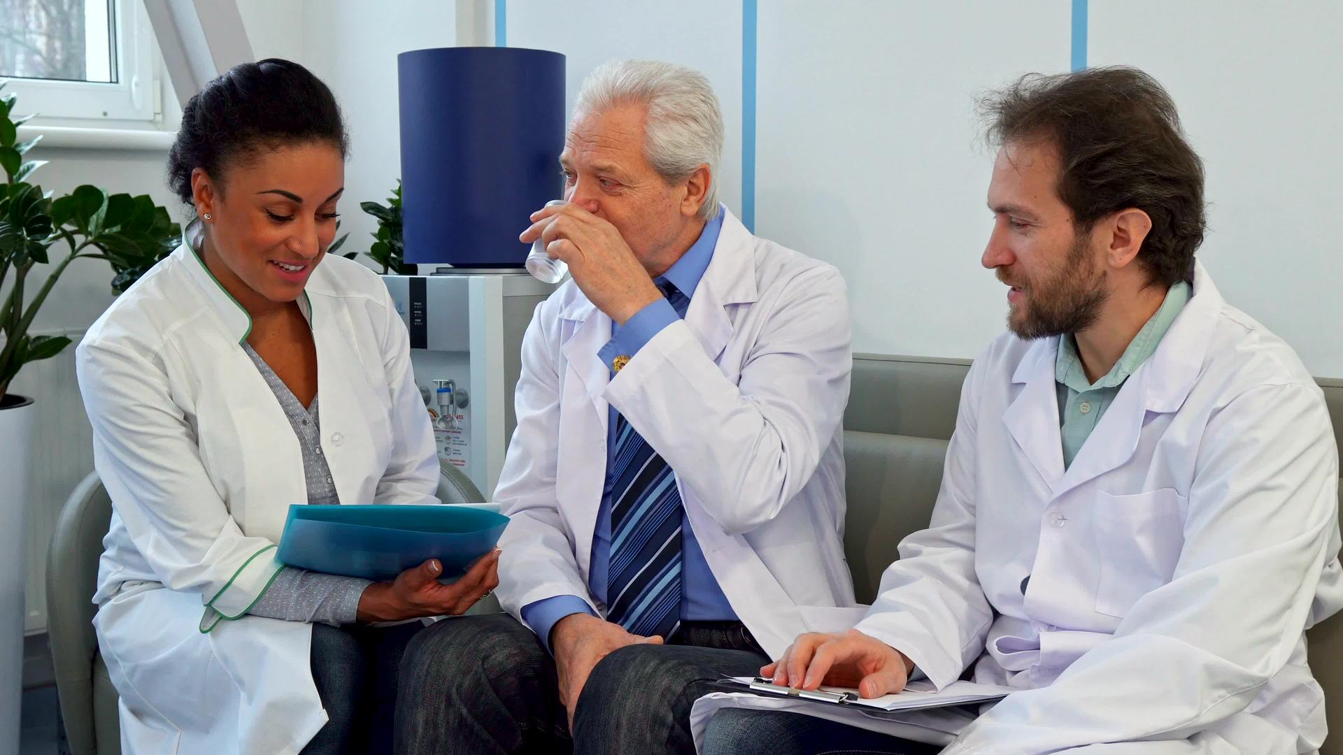 一个由三名医生组成的医疗队坐在医院的沙发上视频的预览图