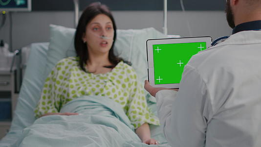 执业医生男子与在床上休息的女性患者讨论问题视频的预览图