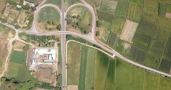 无人机在稻田上空拍摄十字路口和汽车在路上行驶视频的预览图
