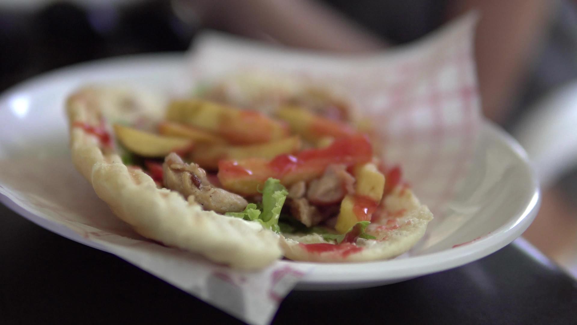 盘子上肉饼三明治的手持镜头视频的预览图