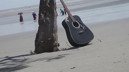 海滩岛上一棵树旁美丽的吉他音乐视频的预览图