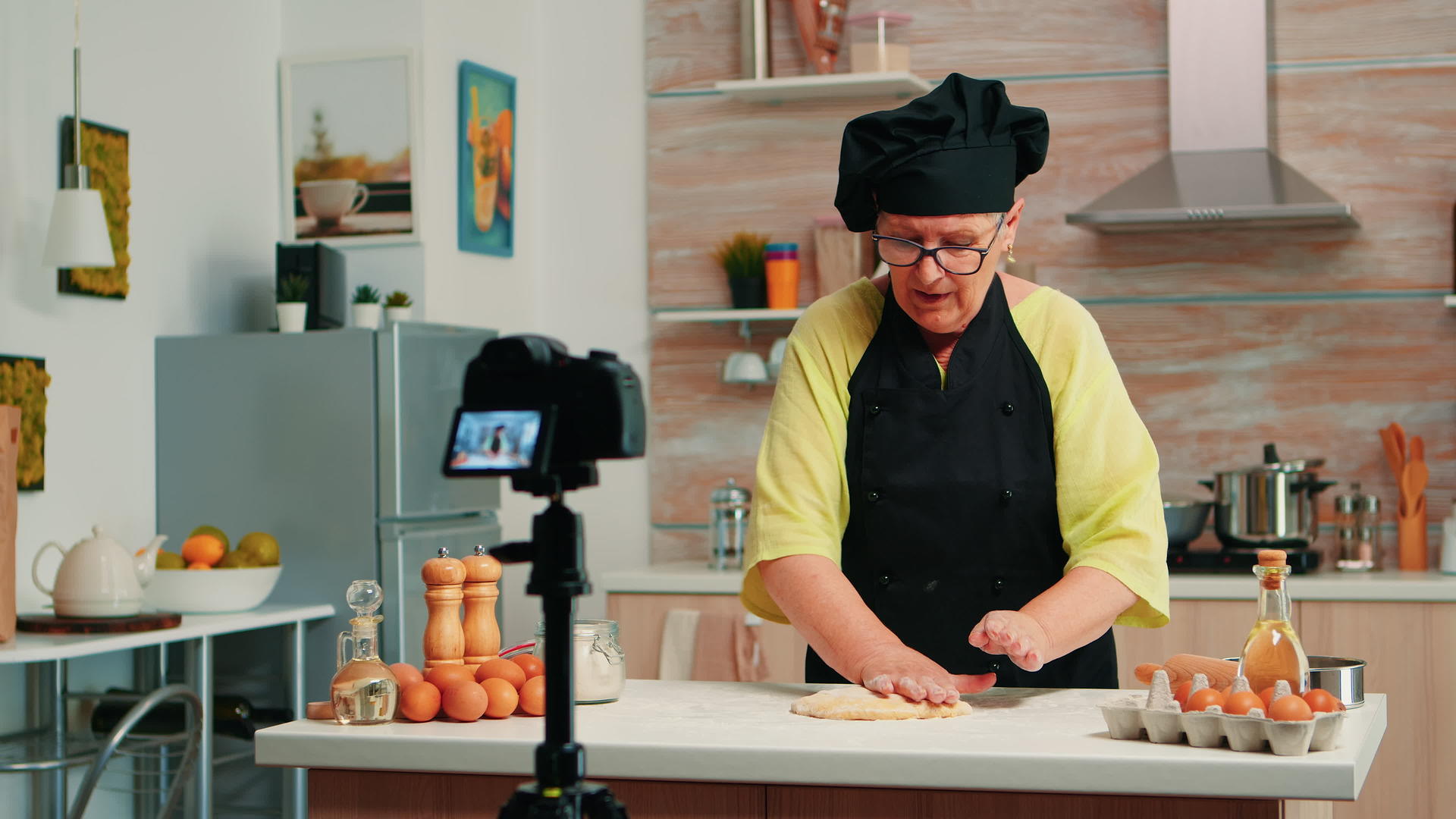 老年妇女在厨房录制食物视频视频的预览图