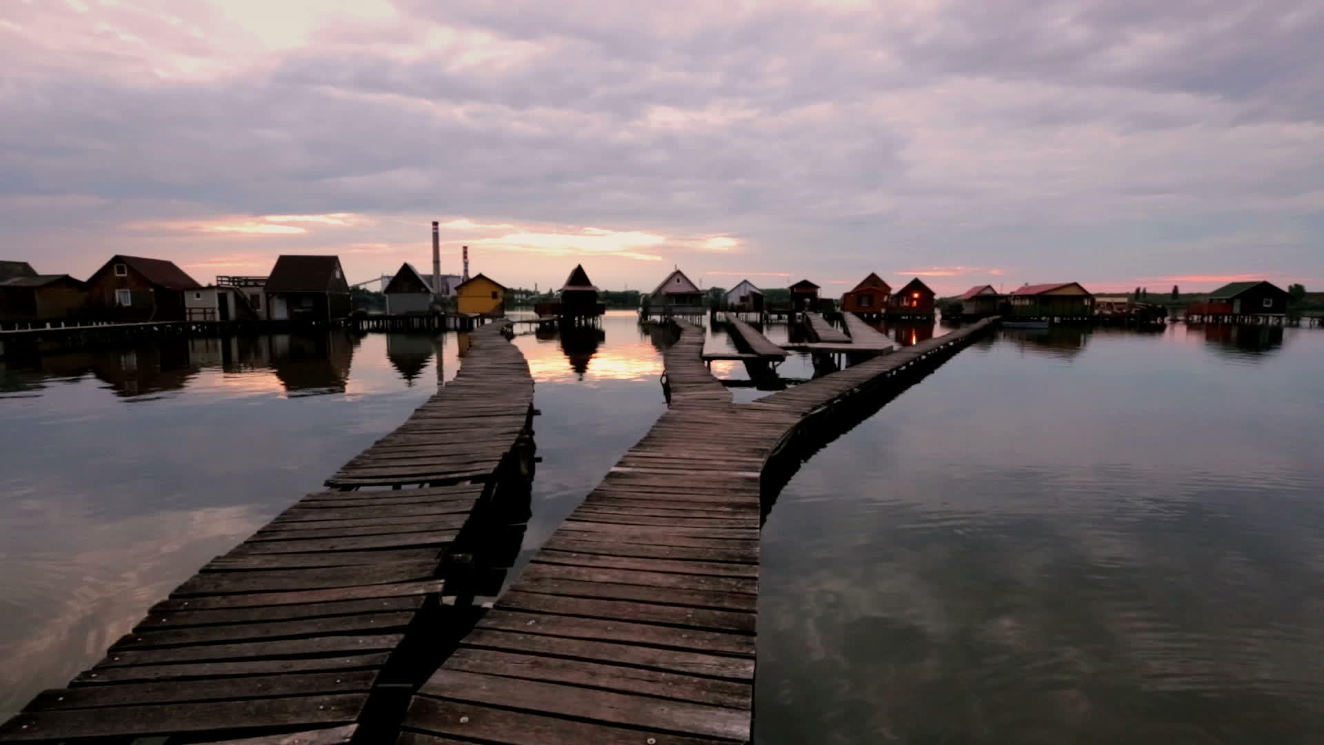 湖面上的日落有木码头和漂浮的房子视频的预览图