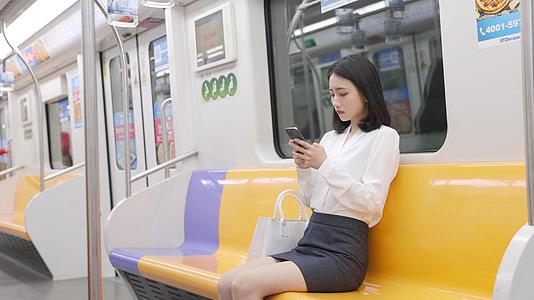 女生放下手机查看地铁下一站信息视频的预览图