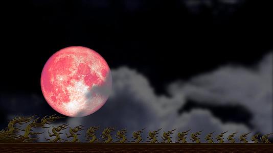 粉红色的月亮云在夜空中模糊了满月的屋顶视频的预览图