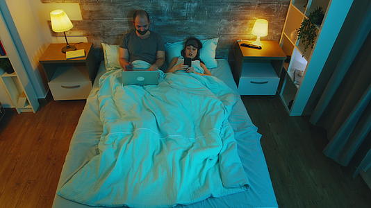 夫妻夫妻睡前看数码产品视频的预览图
