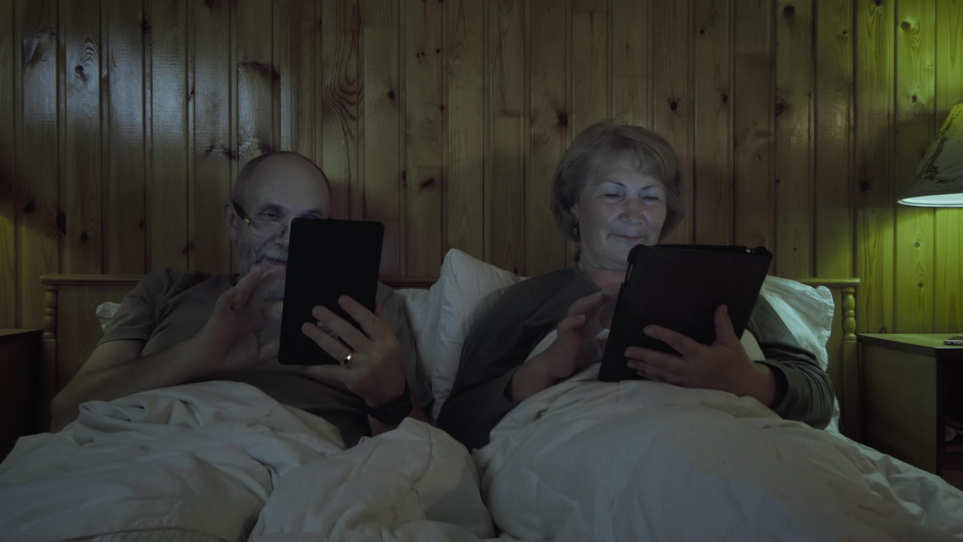 成熟夫妇在床上使用平板电脑视频的预览图