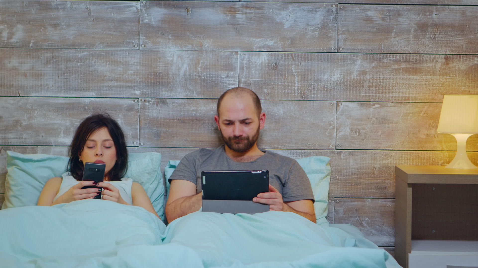 穿着睡衣的年轻女性在丈夫中使用平板电脑视频的预览图