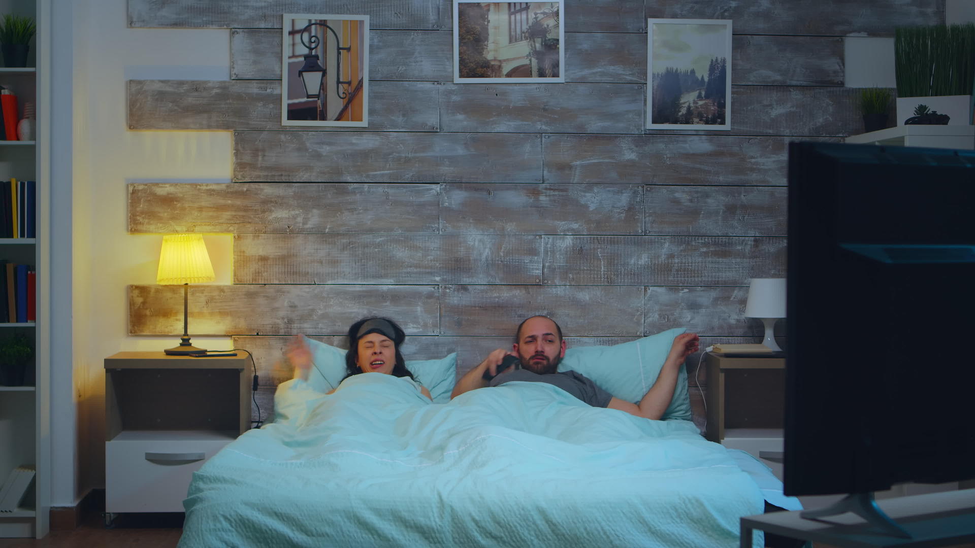 几对年轻夫妇在卧室的床单下睡觉前关灯房间里有月光视频的预览图