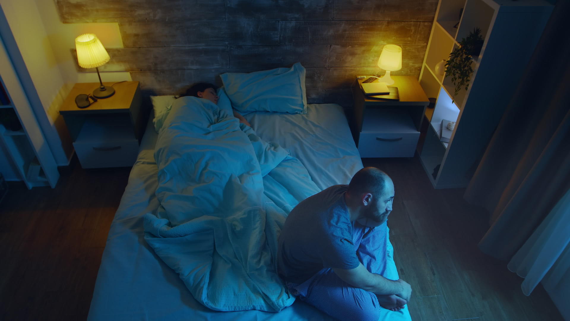 一个年轻人在妻子睡着的时候失眠月光照亮了房间视频的预览图