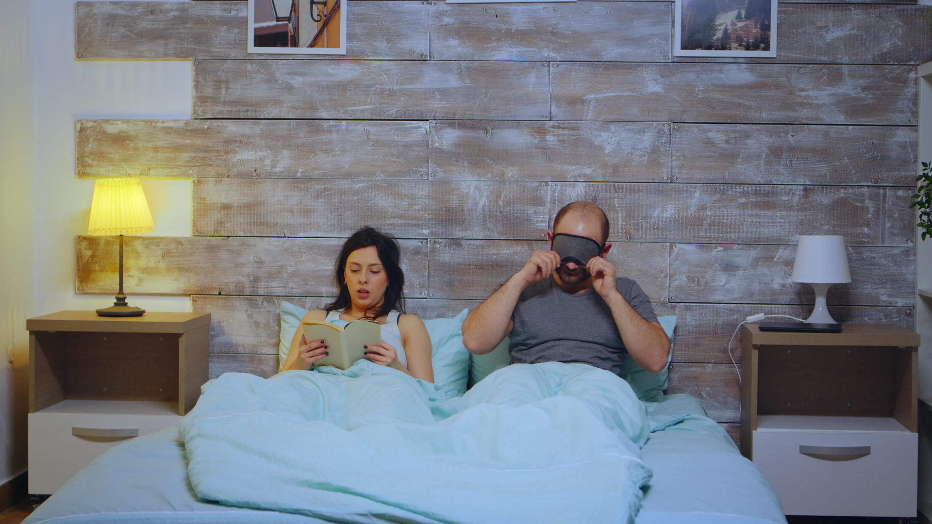 女人读了一本书在卧室里穿着睡衣而她的丈夫则用睡眠面具盖住了它视频的预览图
