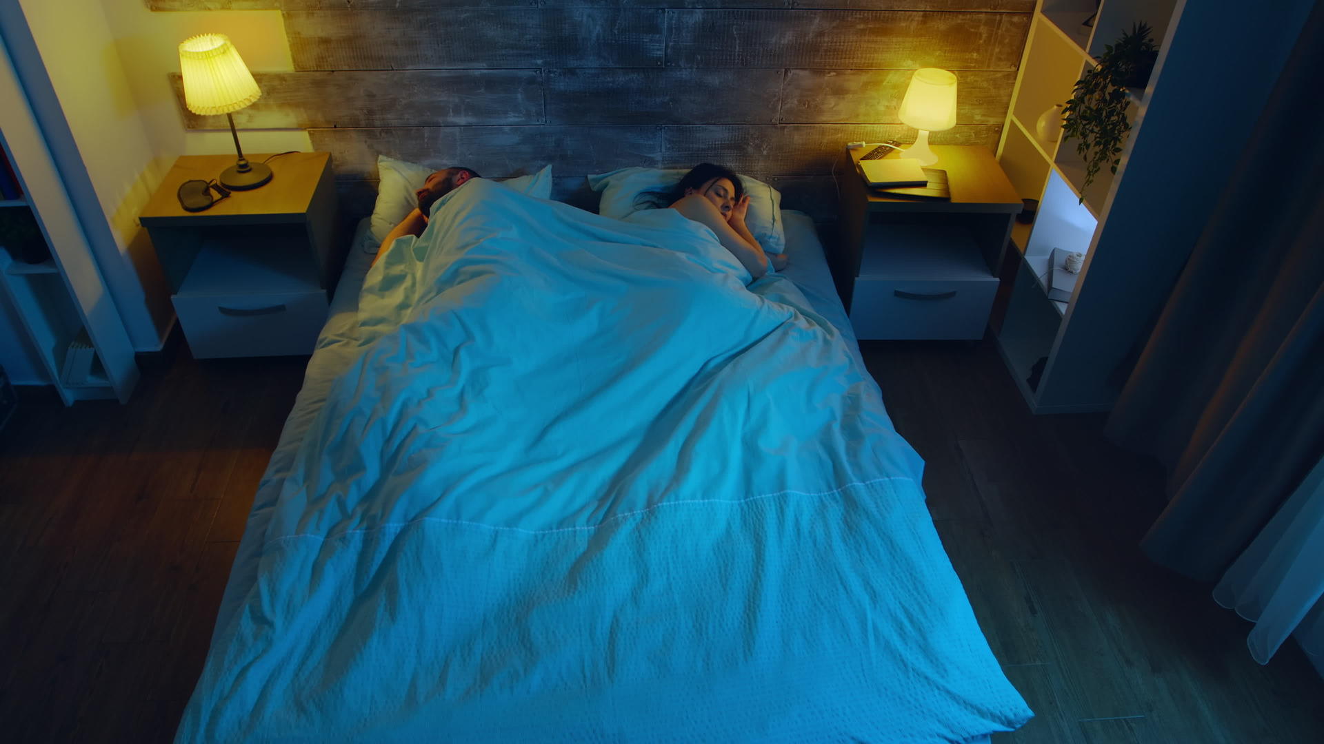 这对年轻夫妇睡在一个房间的顶蓝色的月光从窗户进来视频的预览图