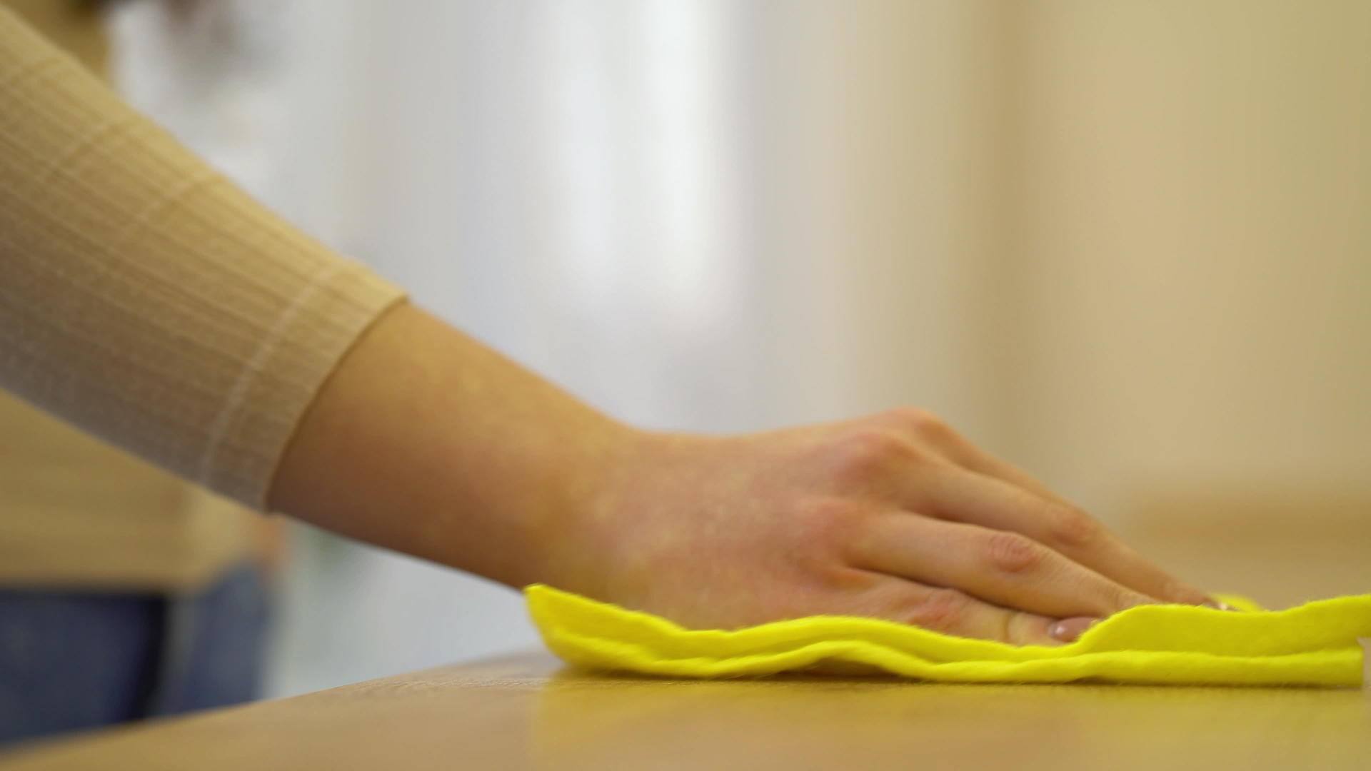 女性用手清洁厨房桌子用黄色消毒布擦拭视频的预览图